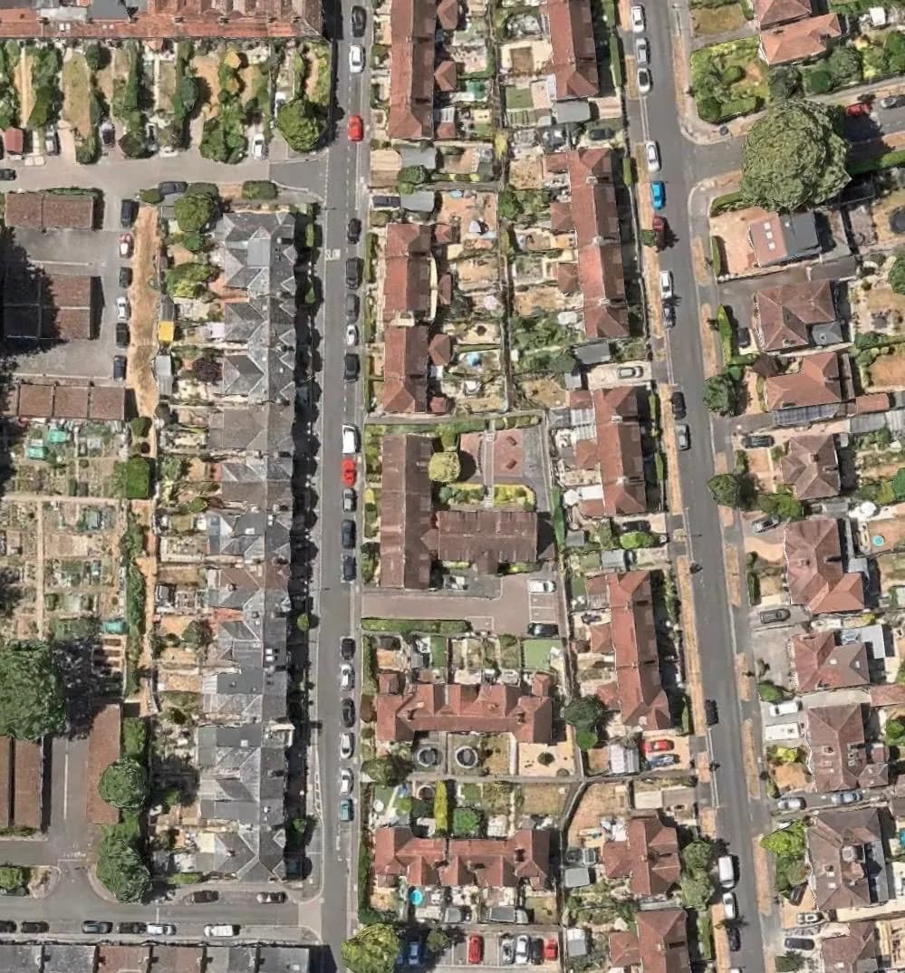 Overhead view of a residential street with houses and gardens, the kind of area covered door to door